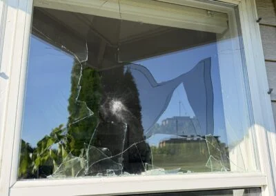 Double-hung window with cracked glass before repair