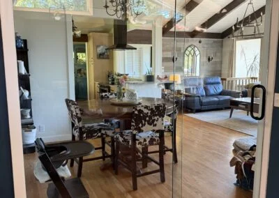 Frameless glass doors opening into a dining and living room