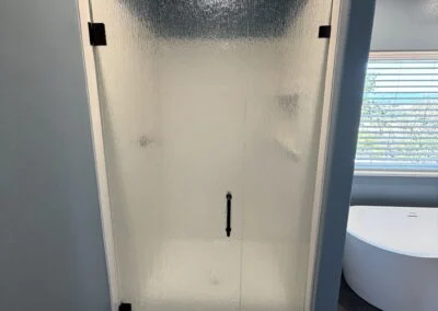Frosted glass shower door with matte black hinges and handle