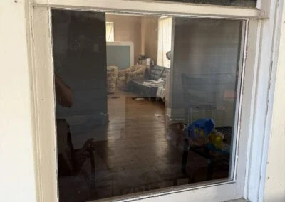 Old window with broken glass removed, looking into a room