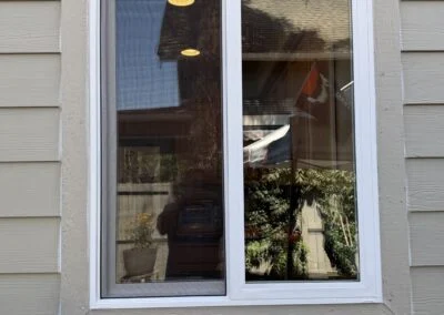 White sliding window set in tan lap siding