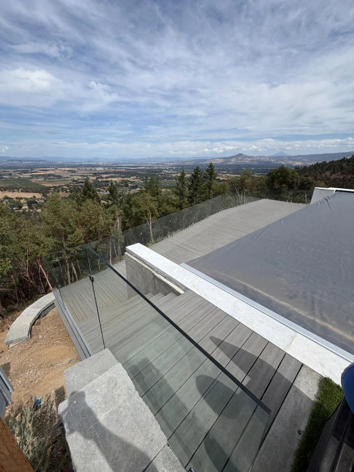 Frameless glass railing panels along a curved deck edge